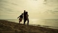 Family enjoy sunset beach. Playful kid girl running around parents at sea shore. Royalty Free Stock Photo