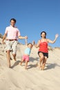 Family Enjoying Beach Holiday Running Down Dune Royalty Free Stock Photo