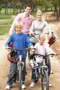 Family enjoying bike ride in park Royalty Free Stock Photo