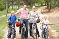 Family enjoying bike ride in park Royalty Free Stock Photo