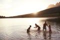 Family Enjoying Evening Swim In Countryside Lake Royalty Free Stock Photo