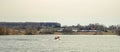 A family enjoying its weekend motor boat ride. Father and his sons in orange life suits against the rural landscape and grey Royalty Free Stock Photo