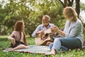 Family enjoying quality time, playing guitar in their green park garden Royalty Free Stock Photo