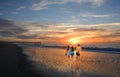 Family enjoying time together on beautiful beach at sunrise. Royalty Free Stock Photo