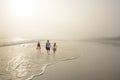 Family Enjoying Time Together On Beautiful Foggy Beach.