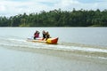 Family enjoying water activities on banana boat at the Kenyir Lake, Terengganu, Malaysia Royalty Free Stock Photo