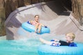 Family enjoying a wet ride down a water slide Royalty Free Stock Photo