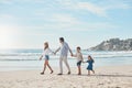 Family is everything. Full length shot of a happy couple holding hands with their two young children and walking along Royalty Free Stock Photo