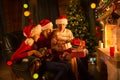 Family exchanging gifts in front of fireplace at Christmas tree Royalty Free Stock Photo