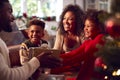 Family Exchanging And Opening Gifts Around Christmas Tree At Home Royalty Free Stock Photo