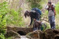 Family Exploration: Three Siblings Exploring Nature with Binoculars and Magnifying Glasses by a Stream