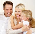 Family, face and happy on sofa with hug, relax and love for bonding and relationship in living room. Parents, girl child