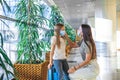 Mother and little girl with medical masks at airport. Protection against Coronavirus and gripp Royalty Free Stock Photo