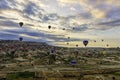 Family of fairy chimneys in Cappadoccia under cloudy skies with hot air balloons in the distance Royalty Free Stock Photo