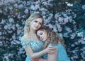 Family fairy photo shoot. Two blond women with wavy hair in luxurious, fabulous, blue dresses against the backdrop of