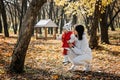 Family Fall Activities. Happy family mom and toddler baby girl feeding the birds outdoors in fall park. Royalty Free Stock Photo