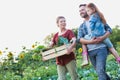 Portrait of a family of famers carrying their vegetables home in wooden boxes, at the end of the day, the Father is carrying their Royalty Free Stock Photo