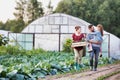 Portrait of a family of famers carrying their vegetables home in wooden boxes, at the end of the day, the Father is carrying their Royalty Free Stock Photo