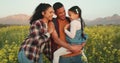 Family, farm and a couple with child in field of flowers, happy, sustainable and together. Man, woman and kid Royalty Free Stock Photo