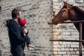 Family on a farm in summer. Father and baby son feed a horse. Outdoor fun for parents and children. Dad and little boy Royalty Free Stock Photo