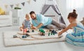 Family father and children play a toy railway in playroom Royalty Free Stock Photo