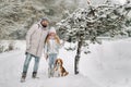 Family father and daughter on a walk with their dog in the winter forest Royalty Free Stock Photo