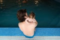 Family of father and his little daughter sitting at edge of swimming pool. Young father and his little cute newborn baby Royalty Free Stock Photo