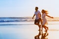 Family - father, mother, baby run on sunset beach Royalty Free Stock Photo