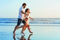 Family - father, mother, baby run on sunset beach Royalty Free Stock Photo