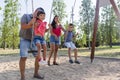 Family with son and daughter having fun playing with the swing in a park. Royalty Free Stock Photo