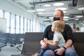 Family father in respiratory mask with a child at the airport waiting for their departure Royalty Free Stock Photo