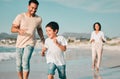 Family, father and son running on beach with mother, ocean and energy with bonding on holiday, happiness and freedom Royalty Free Stock Photo