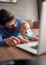 Family - Father using a laptop computer for work at home while l Royalty Free Stock Photo