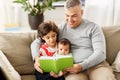 Happy father with sons reading book at home Royalty Free Stock Photo