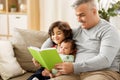 Happy father with sons reading book at home Royalty Free Stock Photo