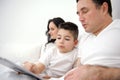 family, fatherhood, technology and people concept happy father and little son with tablet pc computer sitting in bed at Royalty Free Stock Photo