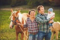 Family feeding horses in a meadow Royalty Free Stock Photo