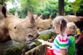 Kids feed rhino in zoo. Family at animal park Royalty Free Stock Photo