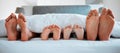 Family feet, bed and blanket in closeup, parents or kids sleeping on holiday in morning, care and relax. Bedroom, people Royalty Free Stock Photo