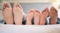 Family feet, bed and closeup with kid to relax with love, rest and sleeping on hotel mattress for vacation. Parents Royalty Free Stock Photo