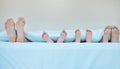 Family, feet in bed and parents with children in home together to relax, bonding and love. Mother, father and kids in Royalty Free Stock Photo