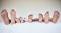 Family feet, bed and parents with kids to relax with love, rest and sleeping on hotel mattress for vacation. People Royalty Free Stock Photo