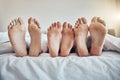 Family feet, bed and together with kid, parents and sleeping on holiday for bonding, care and happiness. Bedroom, people Royalty Free Stock Photo