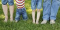 Family feet in jeans on the grass Royalty Free Stock Photo