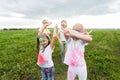 Family, festival of holi and holidays concept - portrait of mothers and daughters covered in paint