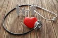 Family figure, red heart and stethoscope on wooden background. Health care concept Royalty Free Stock Photo