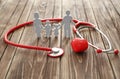 Family figure, red heart and stethoscope on wooden background. Health care concept Royalty Free Stock Photo