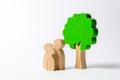 Family figures are standing near the tree. Pastime with family, kinship and parenting. Instilling good qualities and values in a Royalty Free Stock Photo