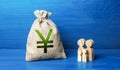 Family figurines and chinese yuan or japanese yen money bag. Family budget. Investment in human capital. Income, expenses. Royalty Free Stock Photo