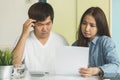 Stressed asian couple looking at issues notification from bank about late payment home loan credit